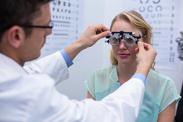Eye doctor performing vision test with phoropter during LASIK consultation exam