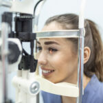 Smiling patient during a slit lamp eye exam at a LASIK consultation