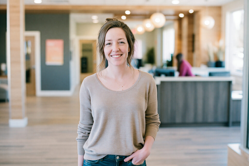 Smiling patient without glasses in a clinic lobby after a LASIK consultation for astigmatism